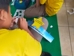 Momen seorang anak membuat hiasan kepala berbentuk bintang saat acara Hari Anak Misioner Sedunia Minggu, 4 Januari 2026/Agus Weraiter/Komsos Kedu