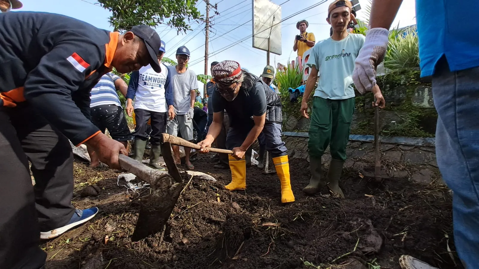 Bupati Temanggung Agus Setyawan (mengenakan ikat kepala) mencangkul dalam momen gotong royong bersama warga tujuh desa di Kabupaten Temanggung dan Magelang, Jawa Tengah. Membersihkan lapisan sedimen dan sampah di di daerah irigasi Soropadan di Kecamatan Temanggung, Jawa Tengah, Minggu (25//1/2026).(Tim Komsos Kedu)